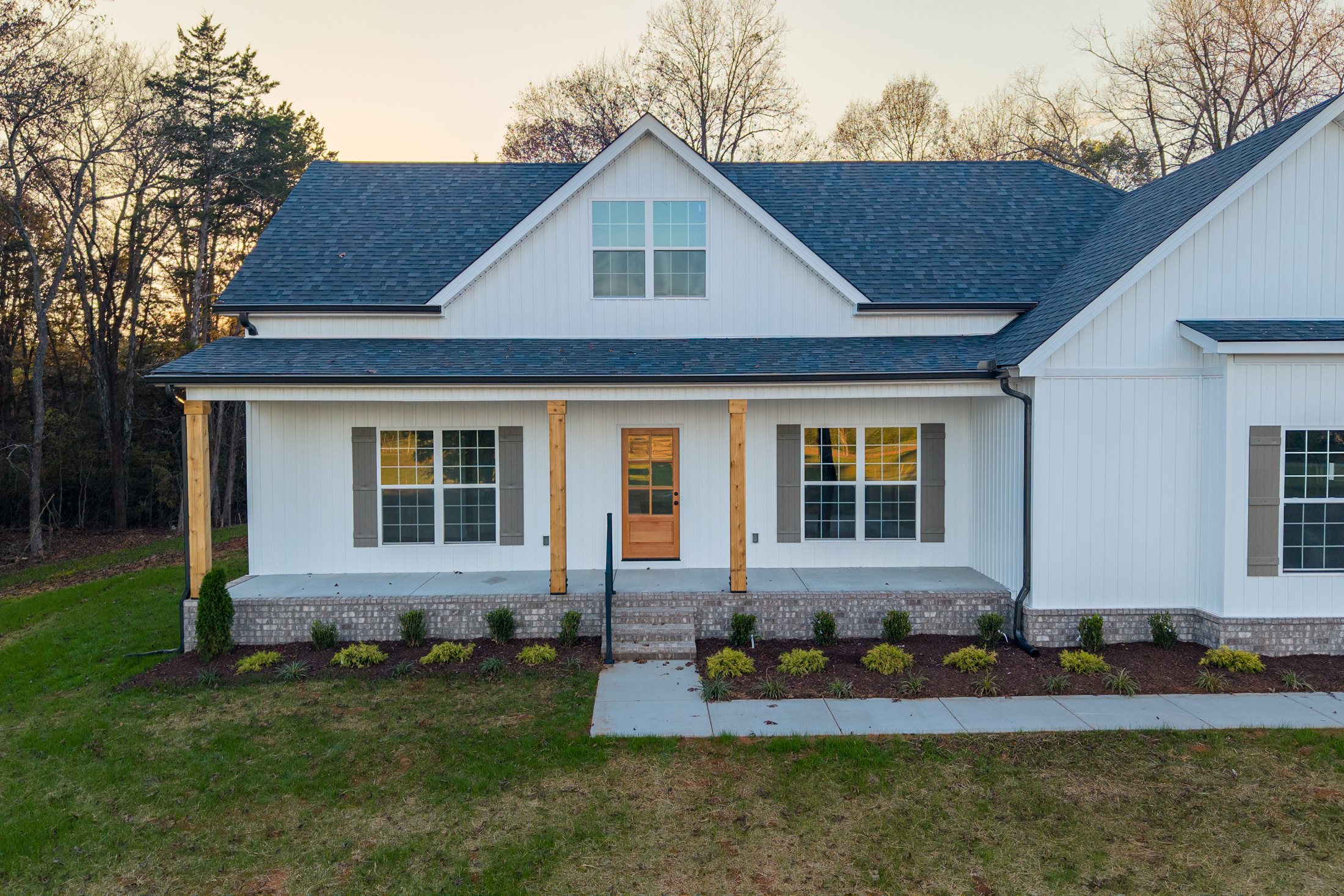 A porch, a tree line, and room to breathe. Golden-hour aerials place this home within the landscape, while closer details bring the story inside.