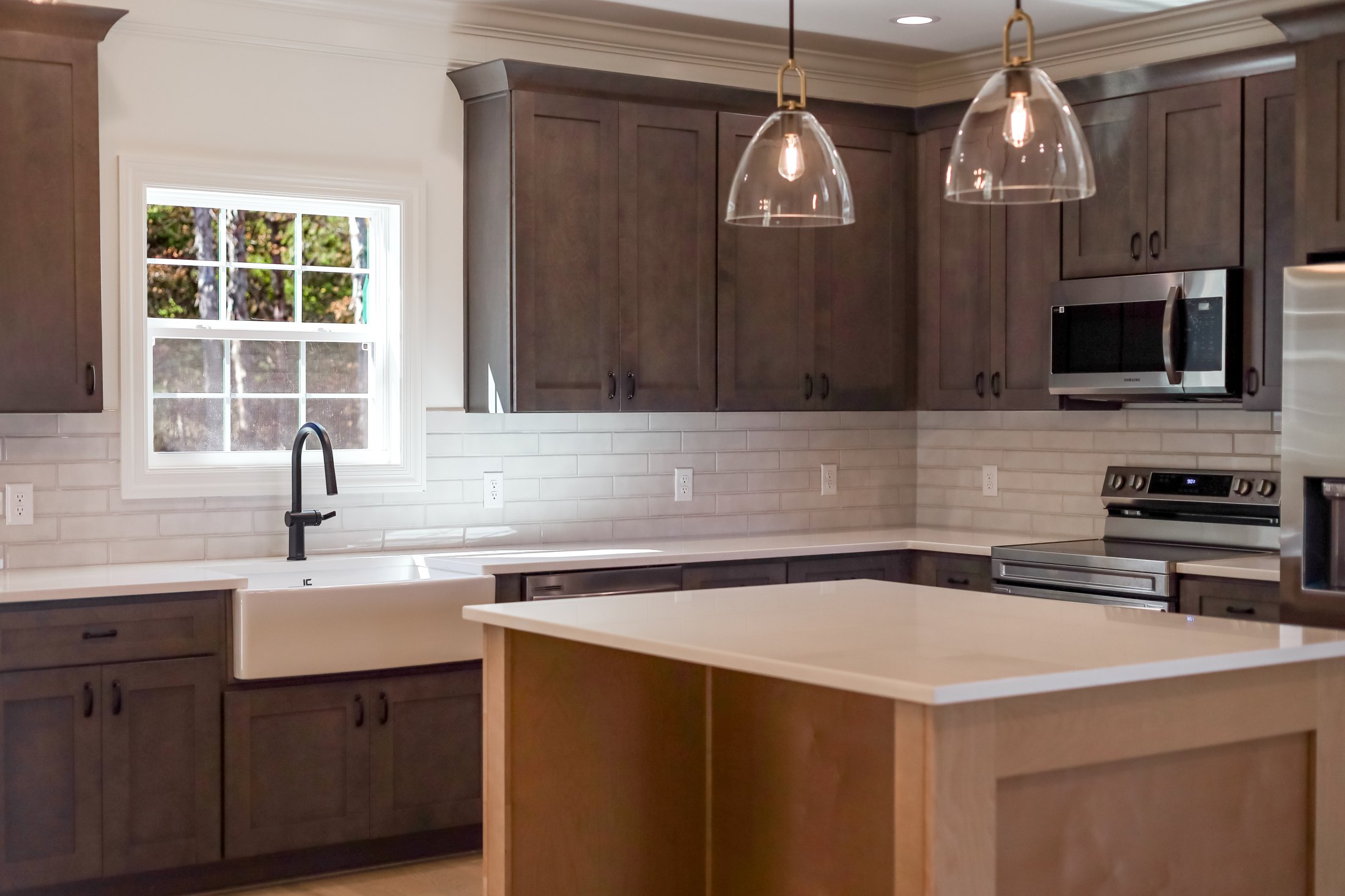Kitchen island with pendant lights and wood cabinetry