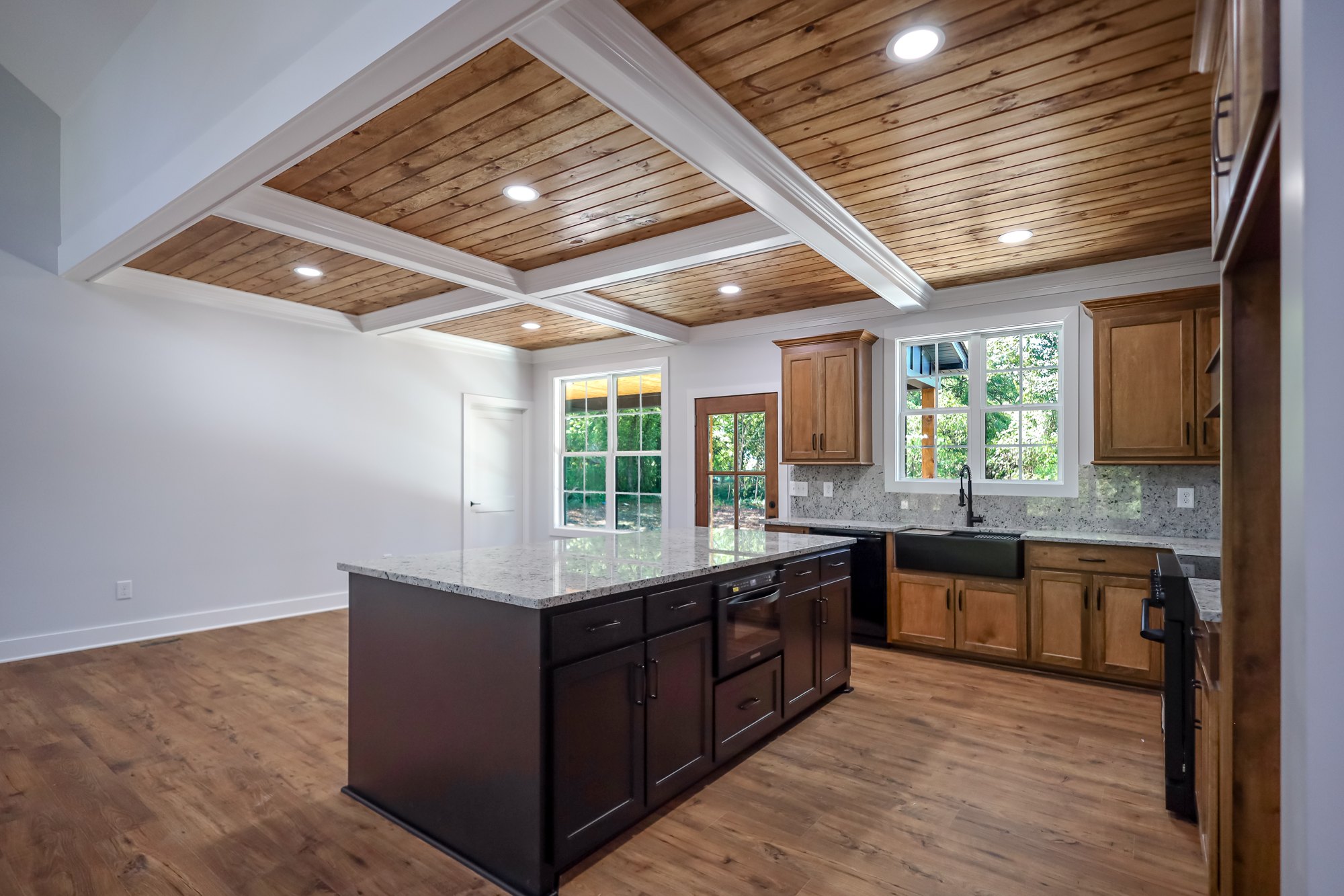 Kitchen with warm wood ceiling and dark island