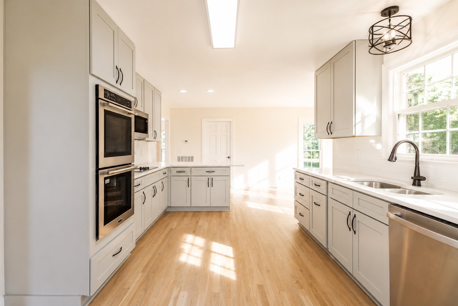 Sunlit white kitchen with wood floors